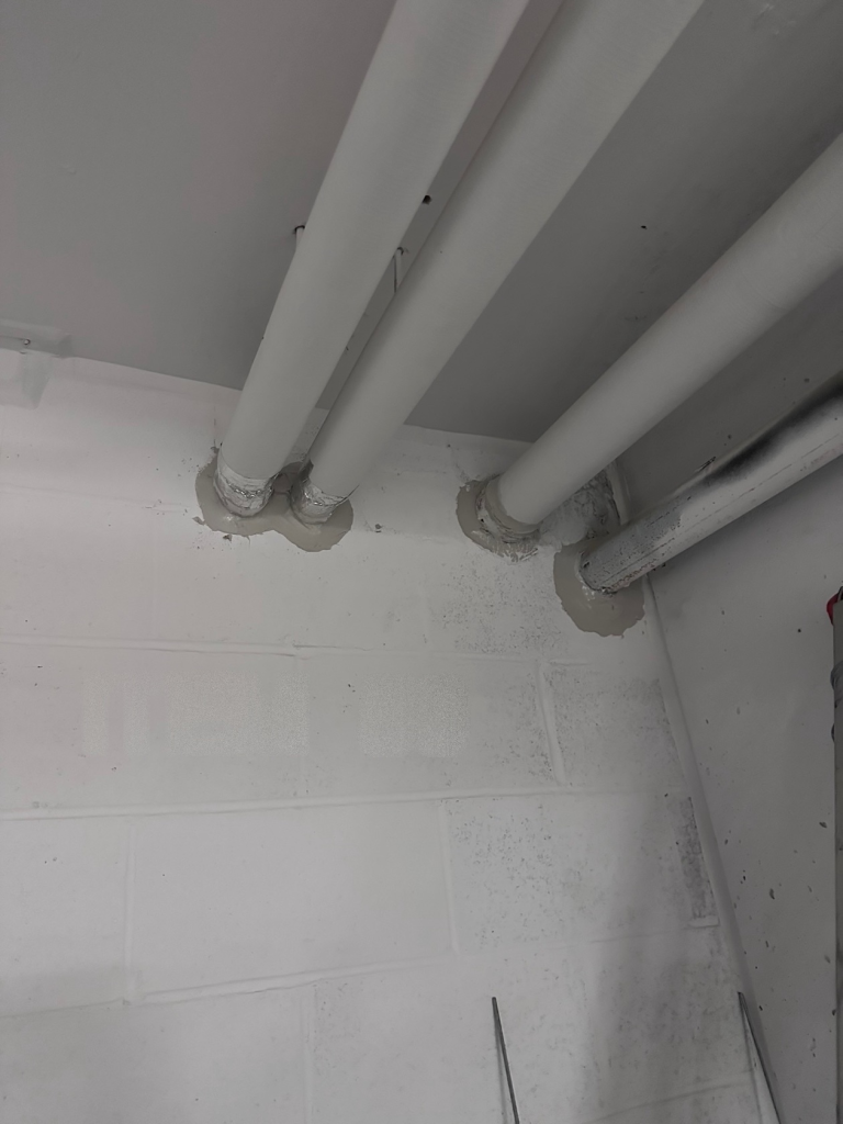 item-56-clean Firestopped pipe penetrations through a block wall